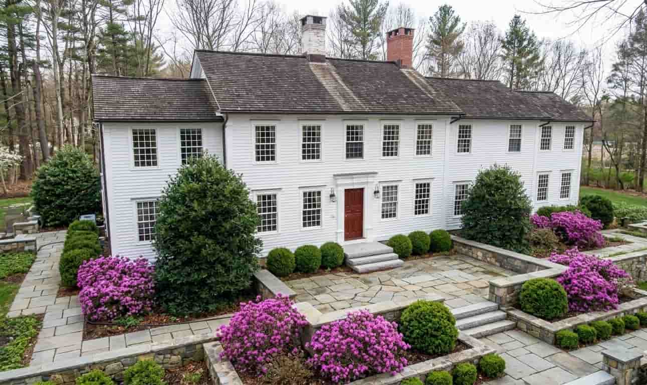 Exterior view of a large white colonial home