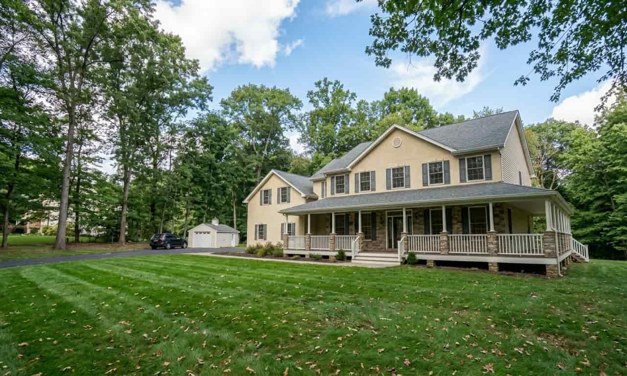 Exterior view of a large tan colonial-style house