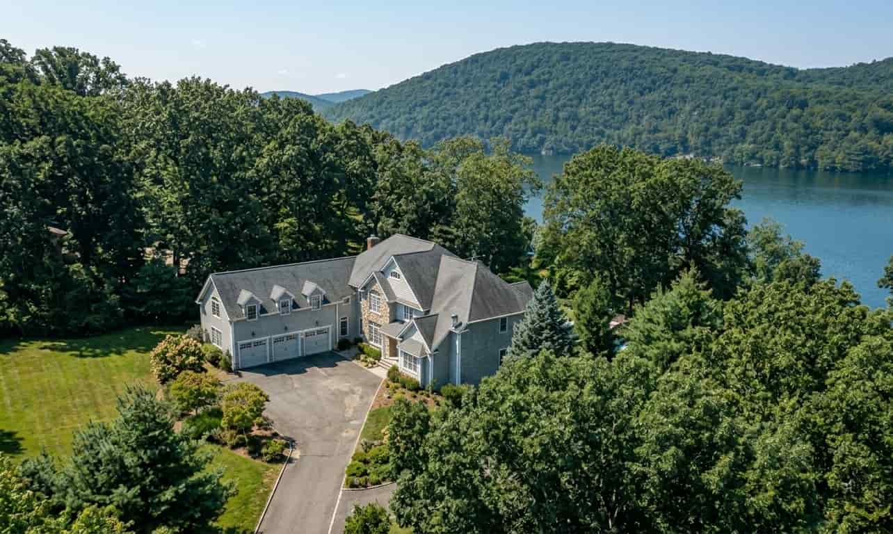 large luxury lakefront home with a gray exterior