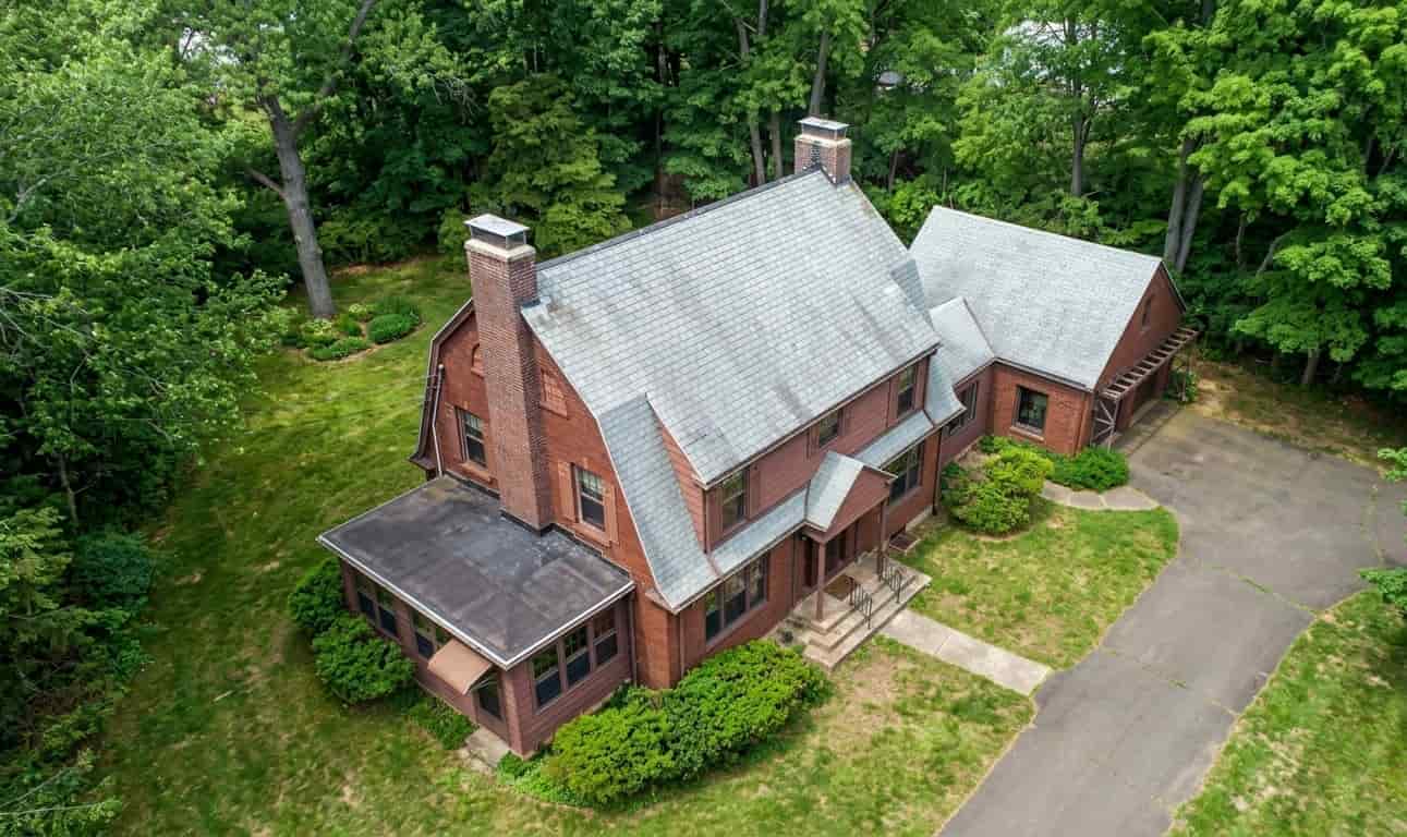 Aerial view of a large, traditional brown brick home