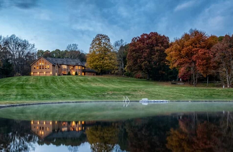 view of a rustic lodge at Hop Brook Lake, perched on a grassy hill