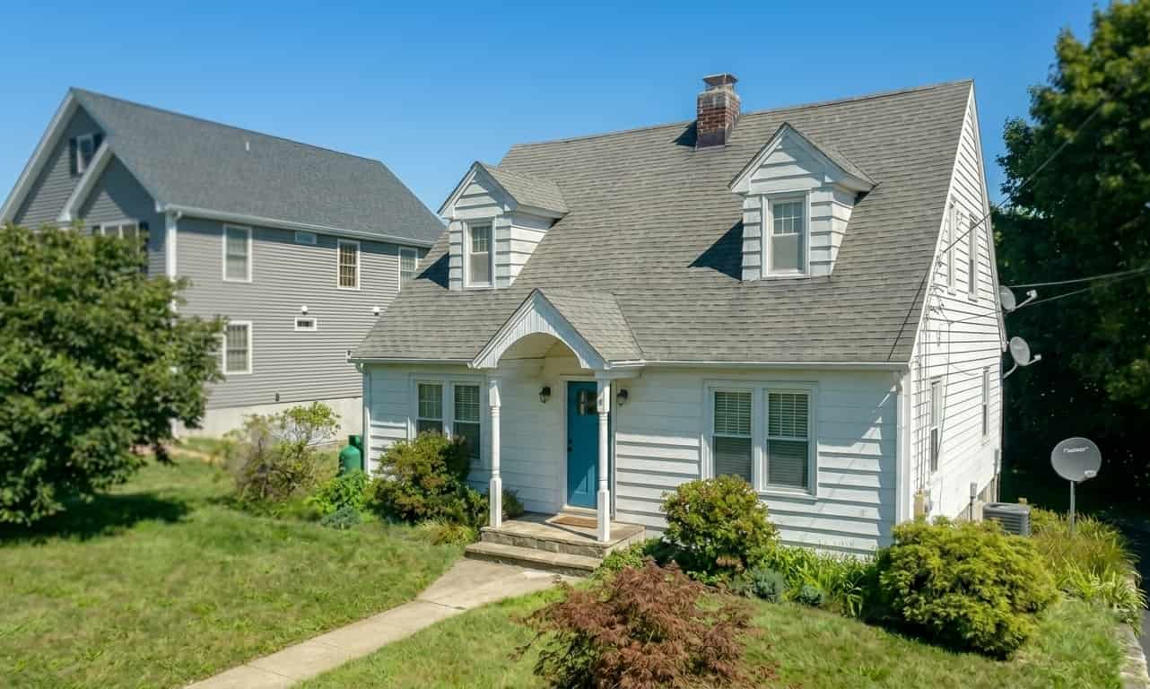 Exterior view of a white Cape Cod style house