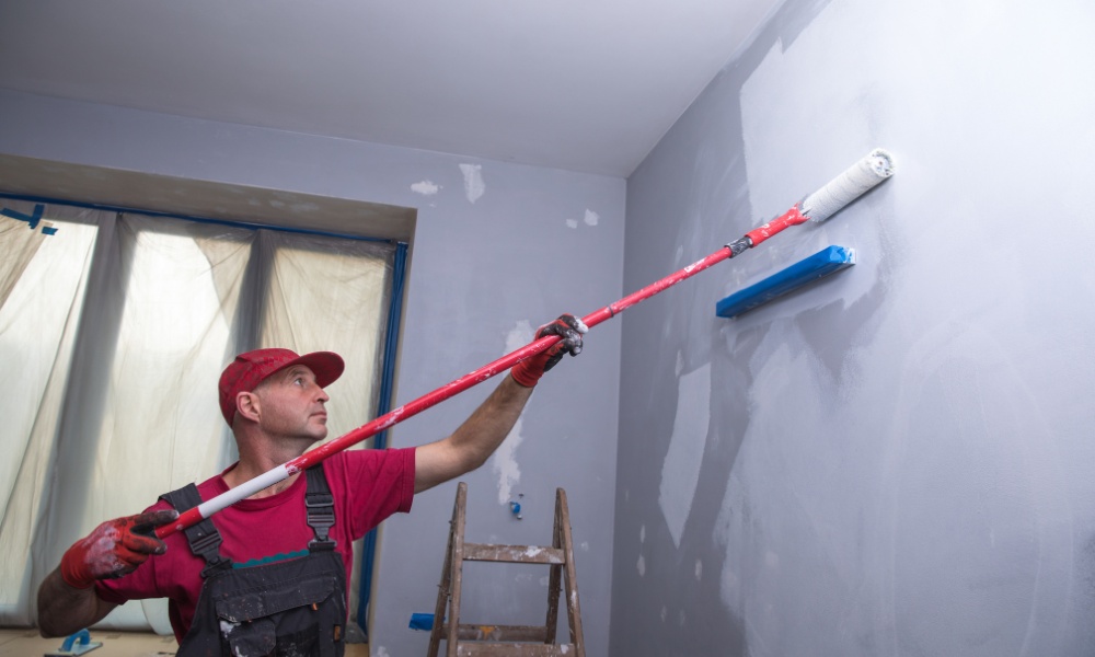 painter using an extension pole roller