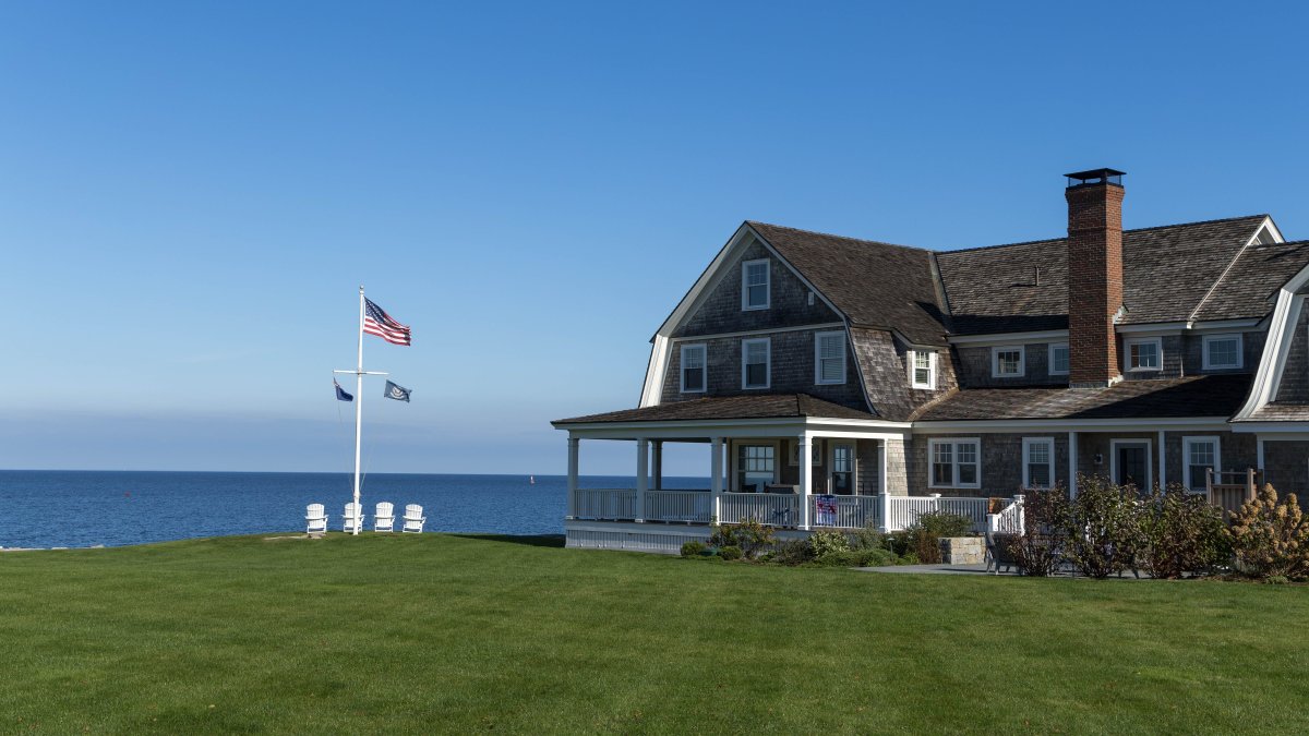 Serene beachfront house with clear blue sky in coastal Connecticut illustrating paint durability in harsh seaside environments.
