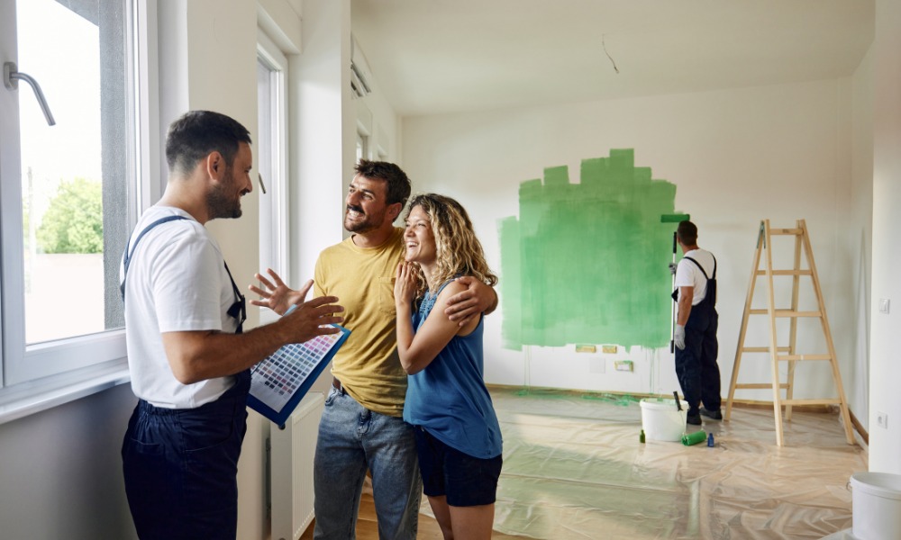 couple holding a color palette board and talking to a painter